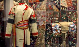 An exhibit case representing the Metis with a quilt, saddle, and robe