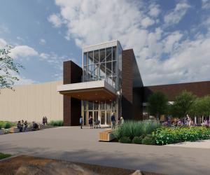 Outdoor rendering of the front of a building with tan walls and copper plated walls with many windows for the entrance. Many plants and trees are shown as well as people walking and sitting on benches.