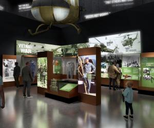 Rendering of people looking at objects, images, and text panels about the Vietnam War. A large green helicopter hangs from the top.
